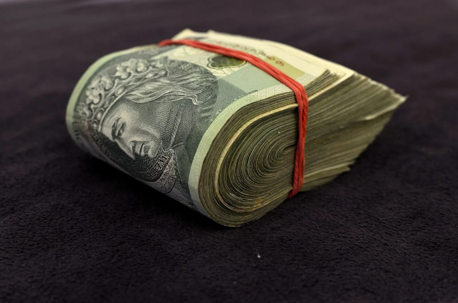 A thick stash of dollar bills wrapped with a elastic band