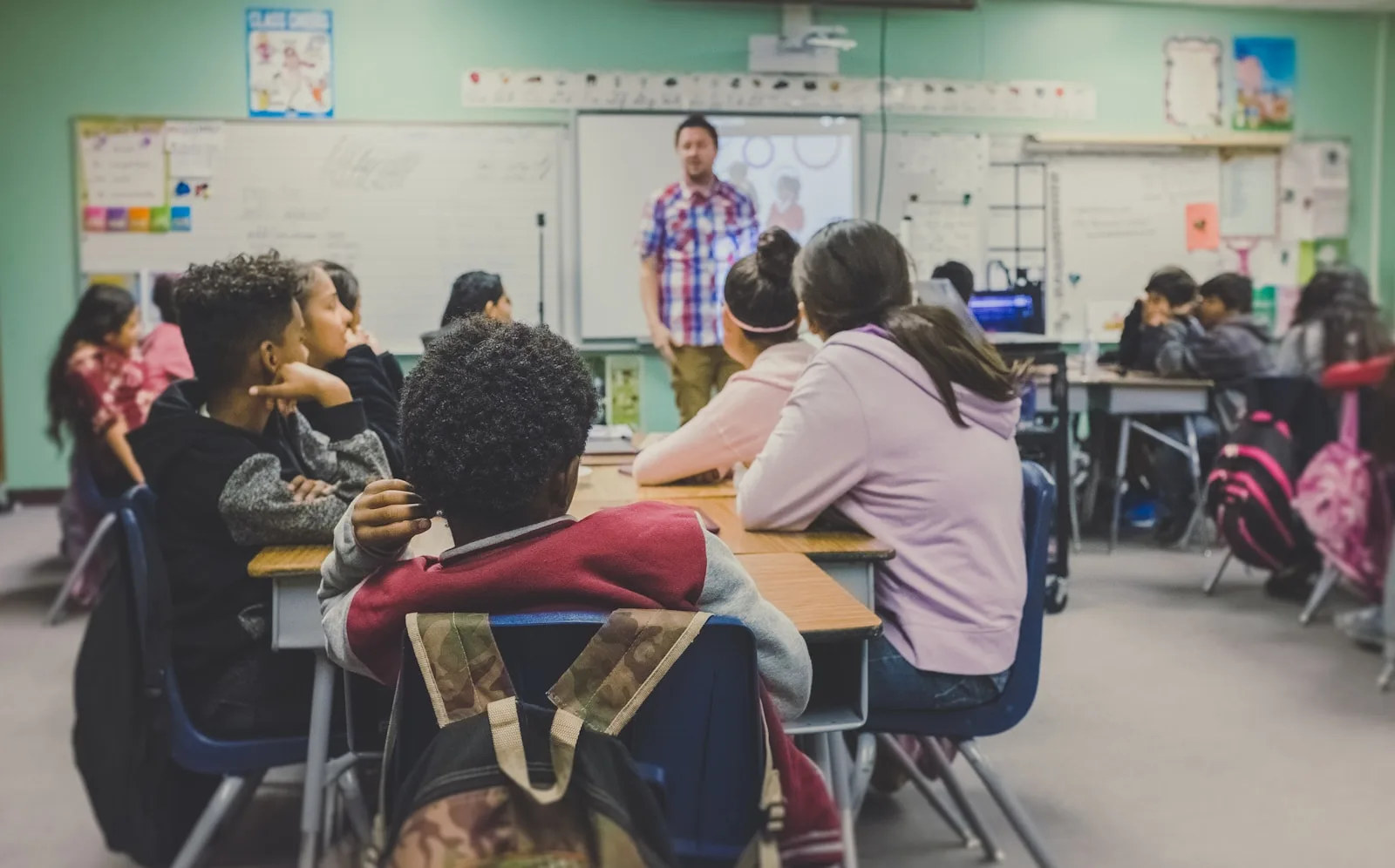 Image of a teacher giving lecture to a group of high school kids
