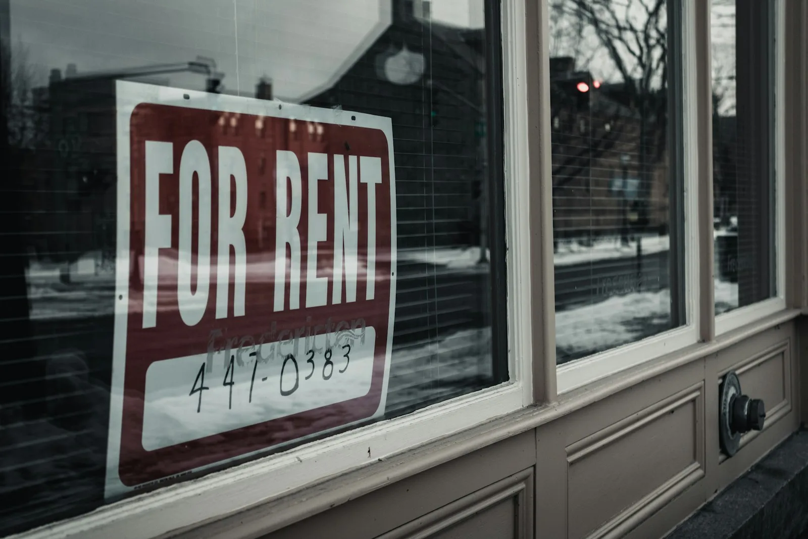 “For Rent” sign on a glass window