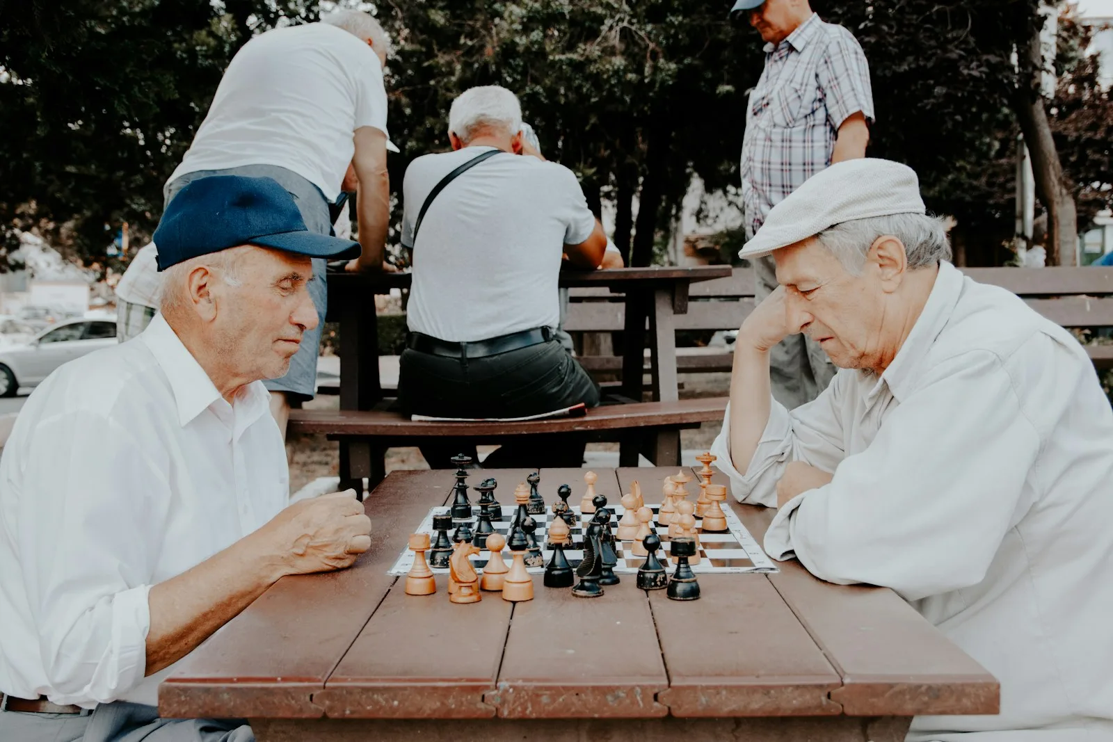 A group of gentleman playing chess in their retirement