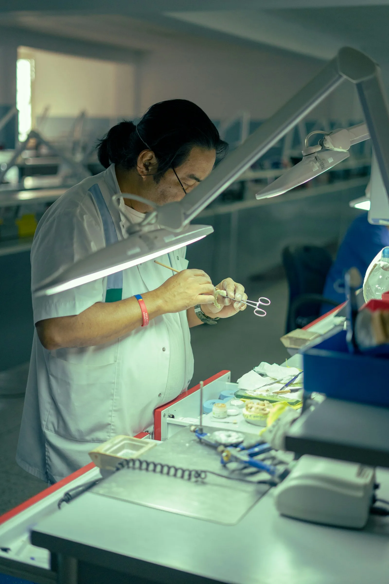 A person testing a specimen with scissor and other medical instruments.