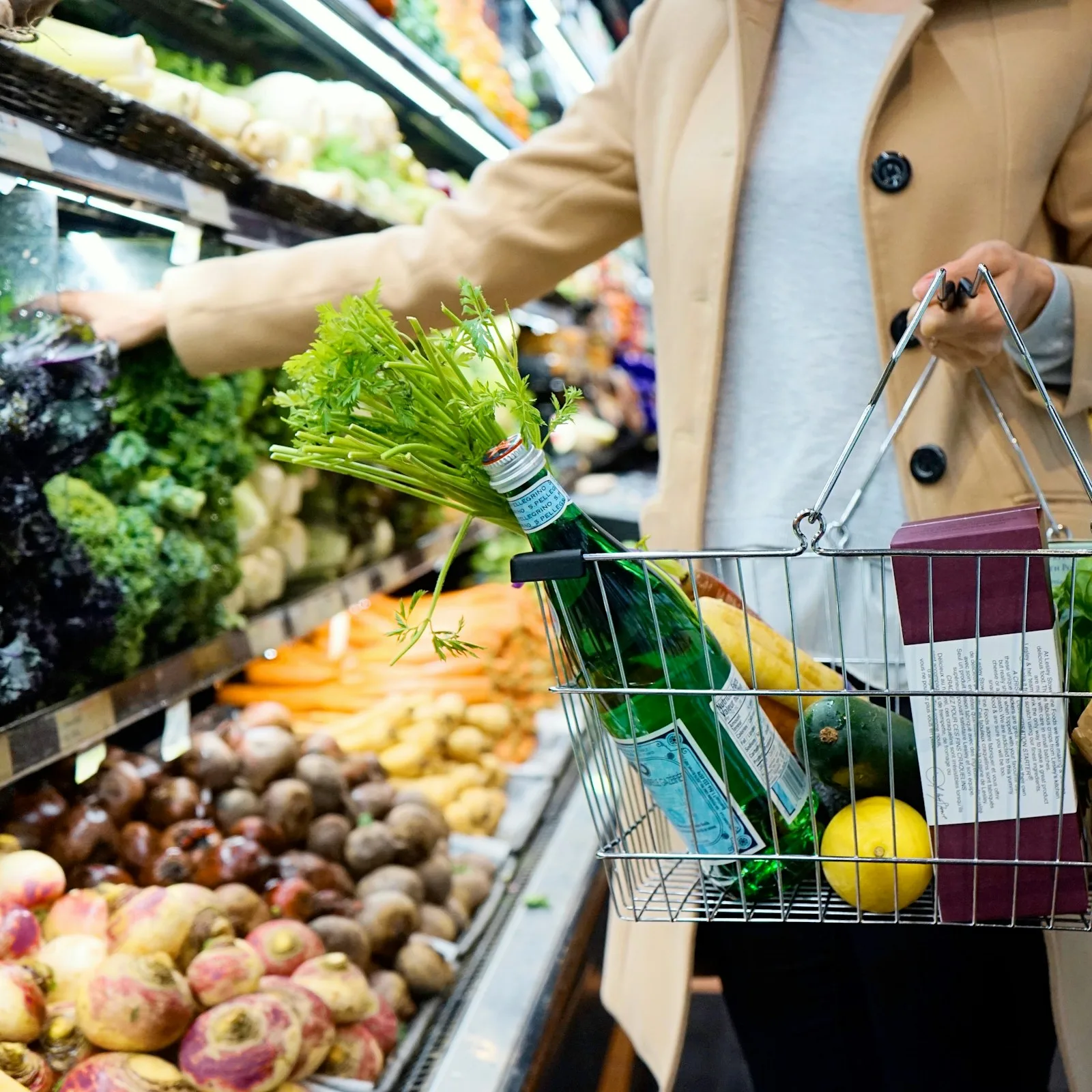 Image of a supermarket trolley with fresh produce and a bottle in it