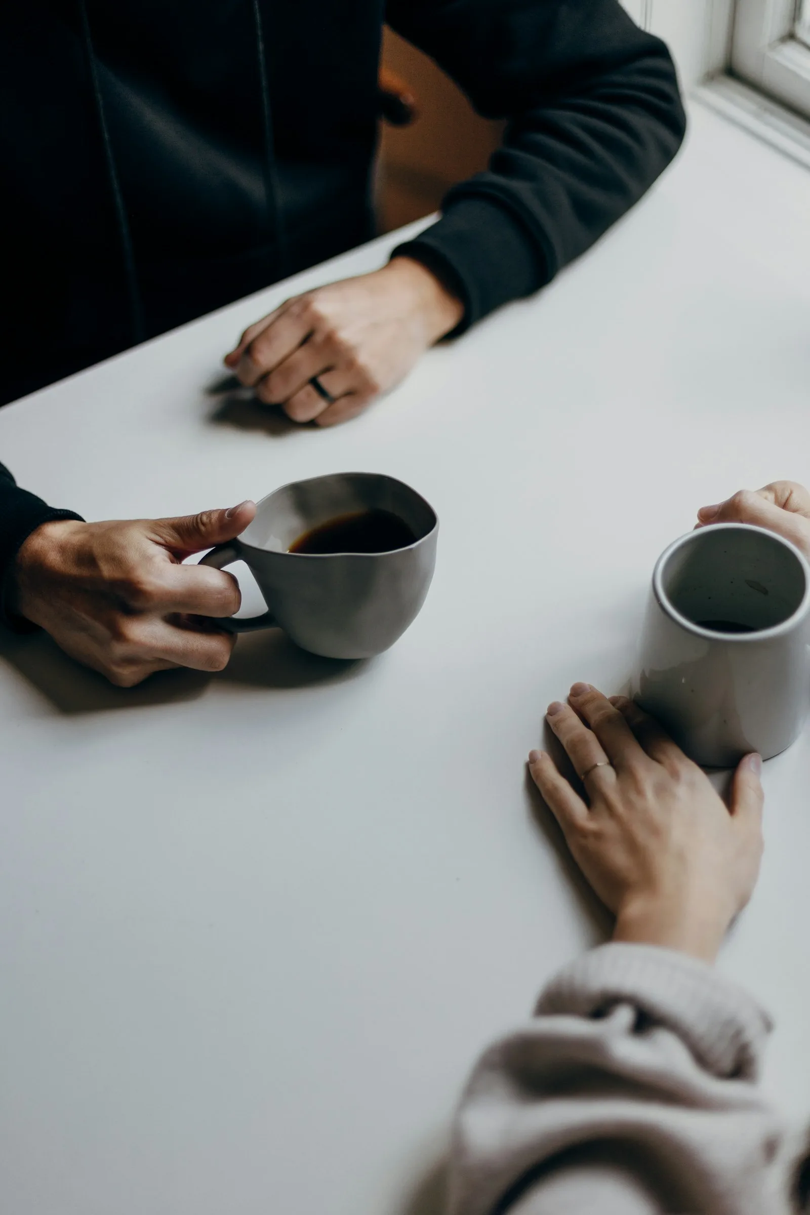 A person taking credit counselling from a professional over a cup of coffee
