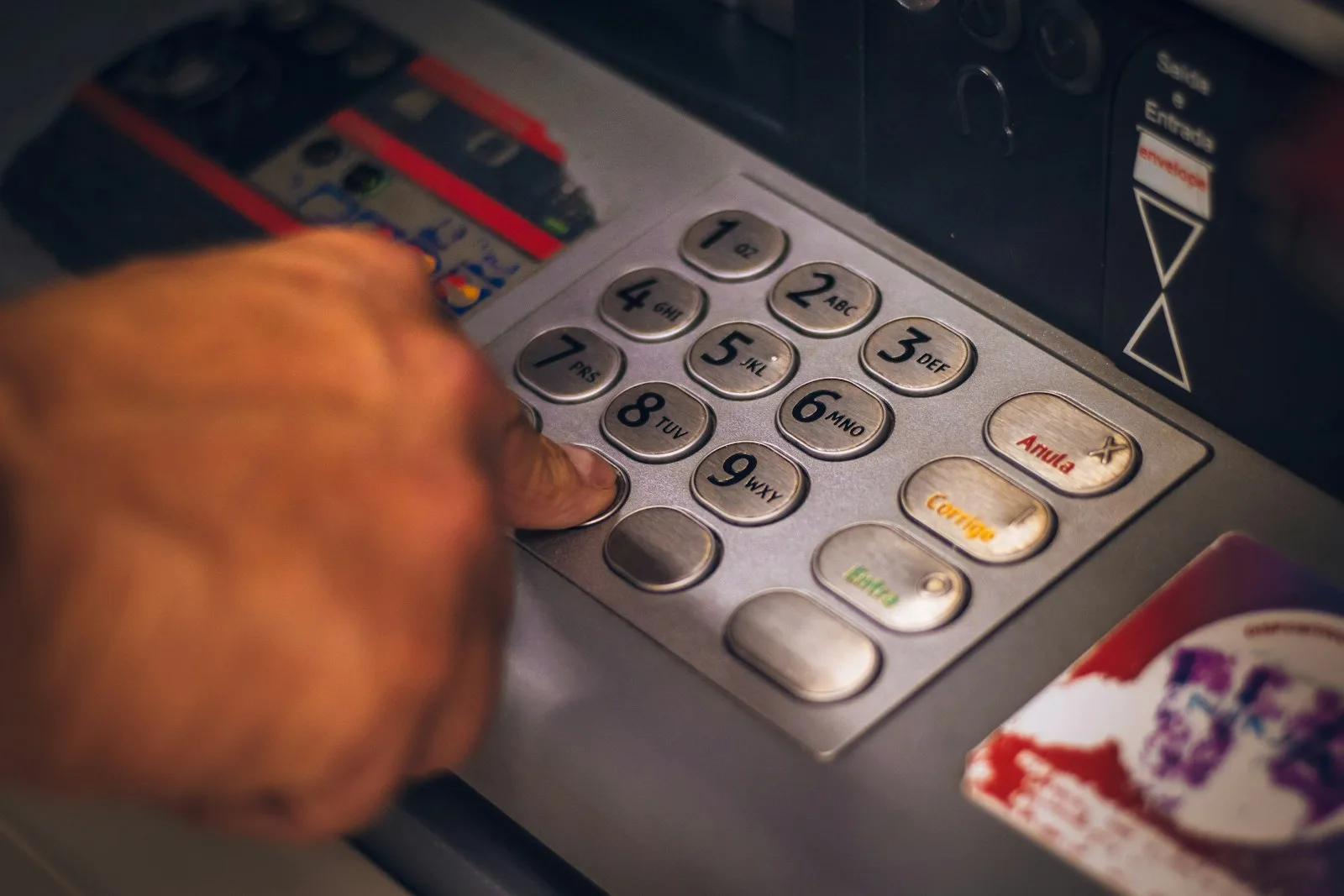 A person entering his credit card pin to withdraw money from their ATM