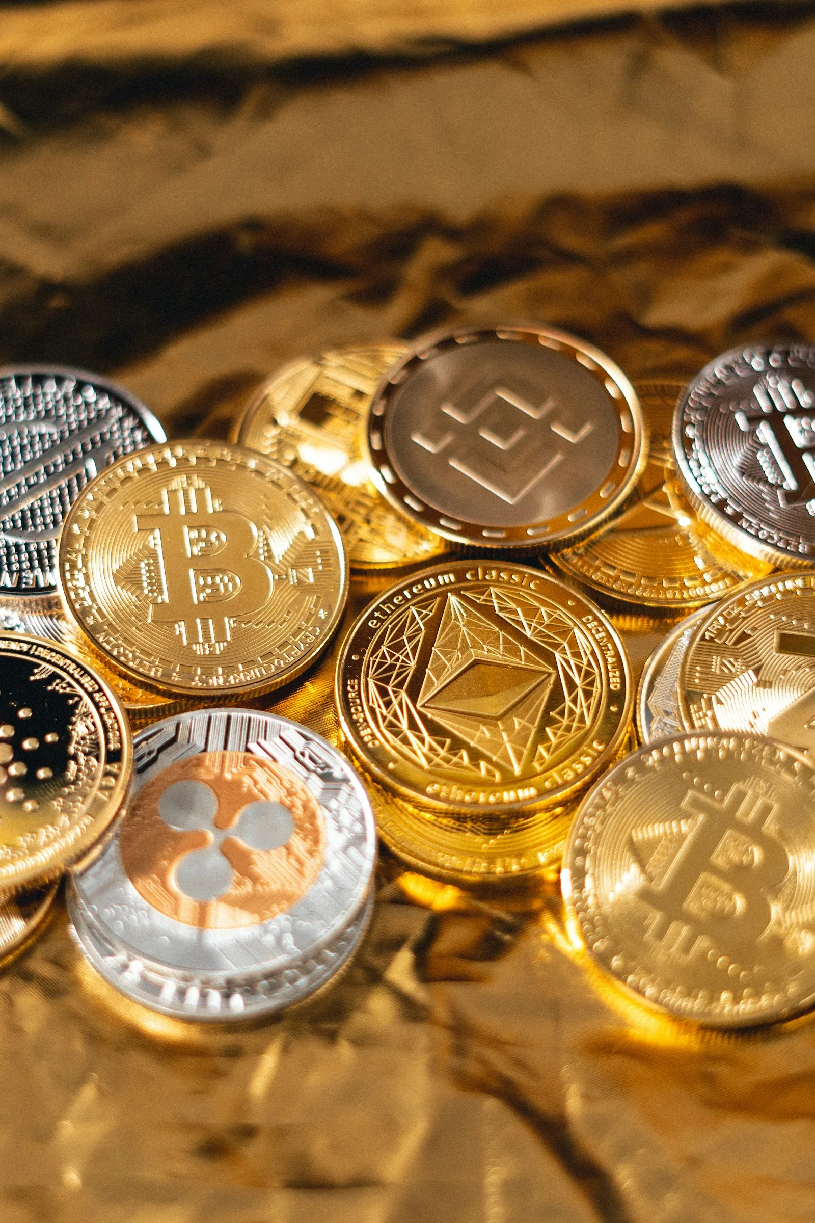 Photo of multiple cryptocurrency symbols printed on top of physical coins