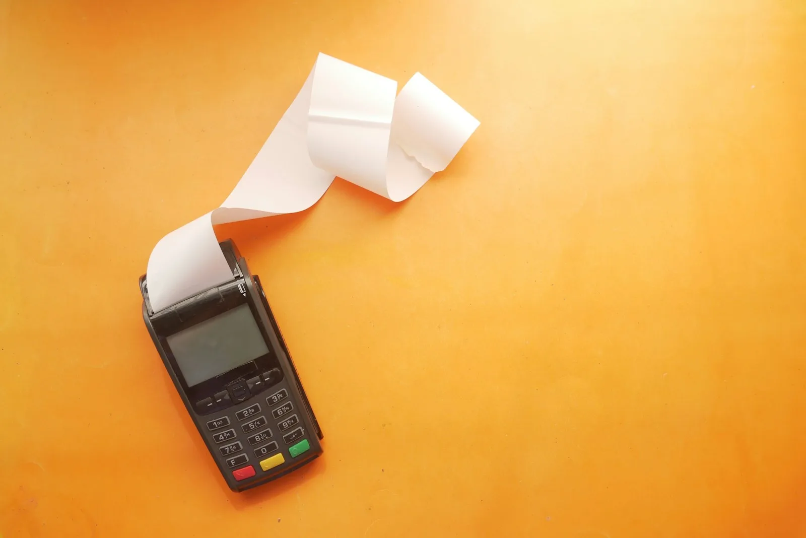 Image of a card swiping machine printing a very long receipt