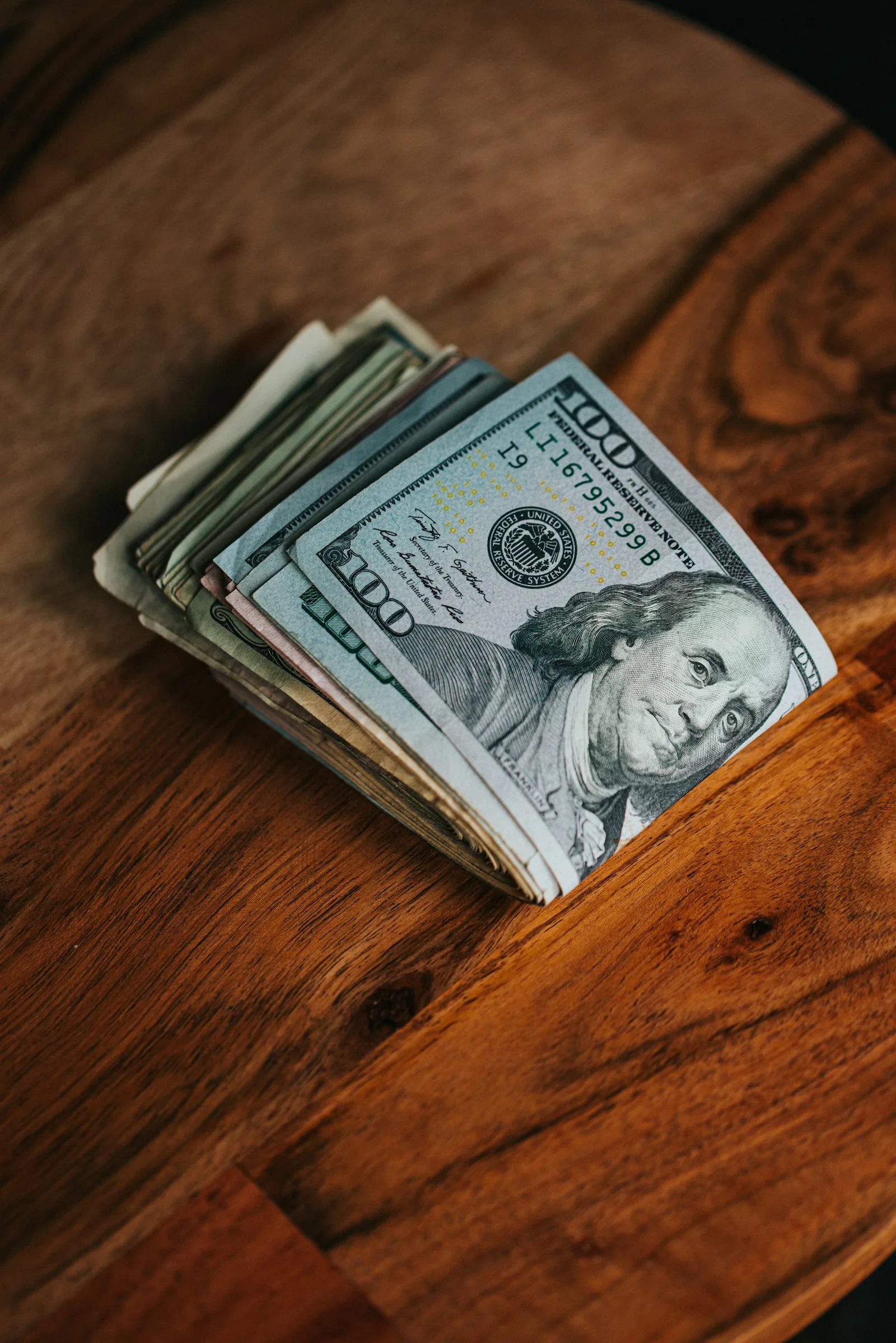 A stack of dollar bills on a table.