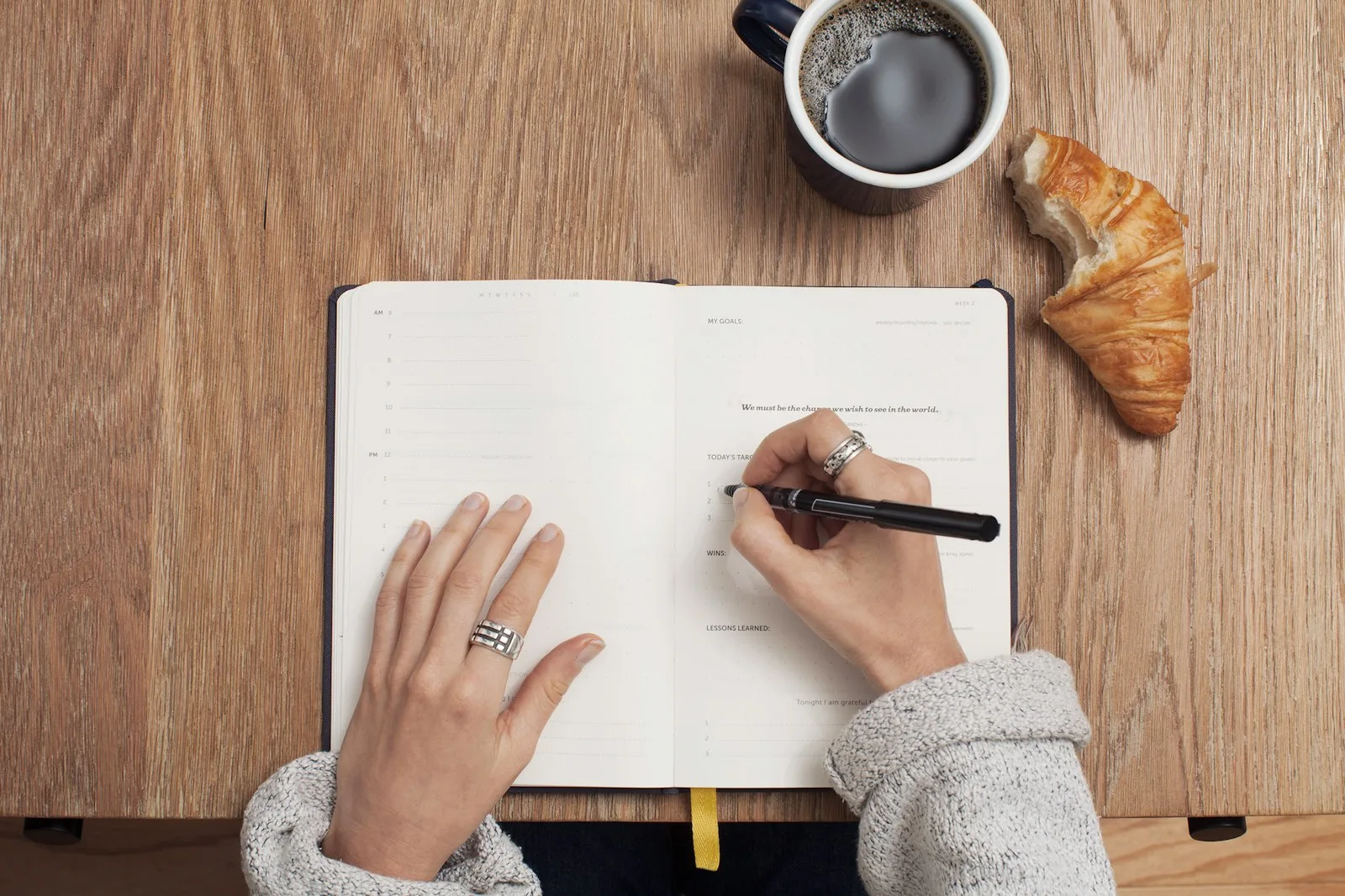 A person trying to create a budget on a notepad