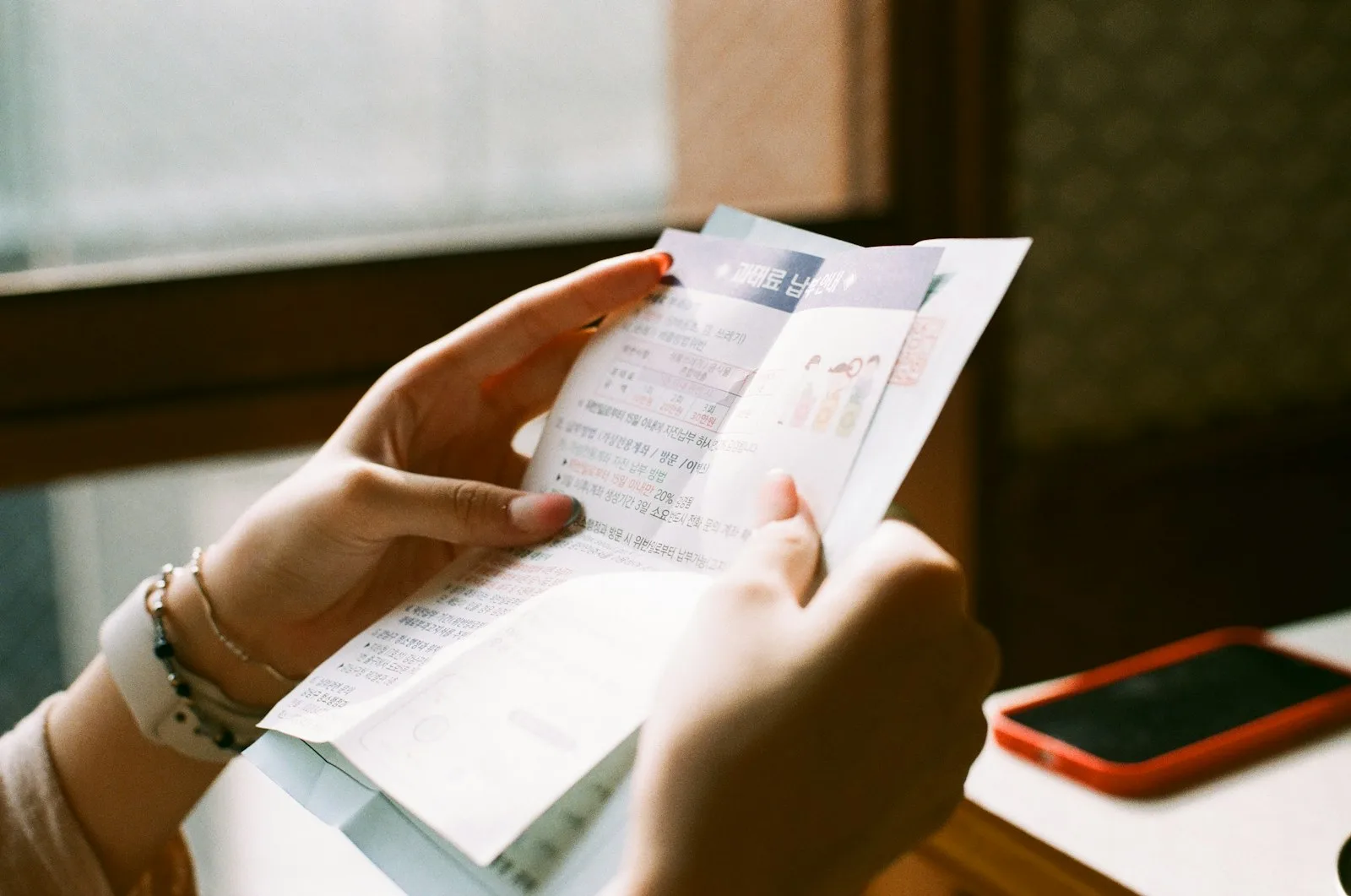 Image of a person holding up multiple bills / receipts