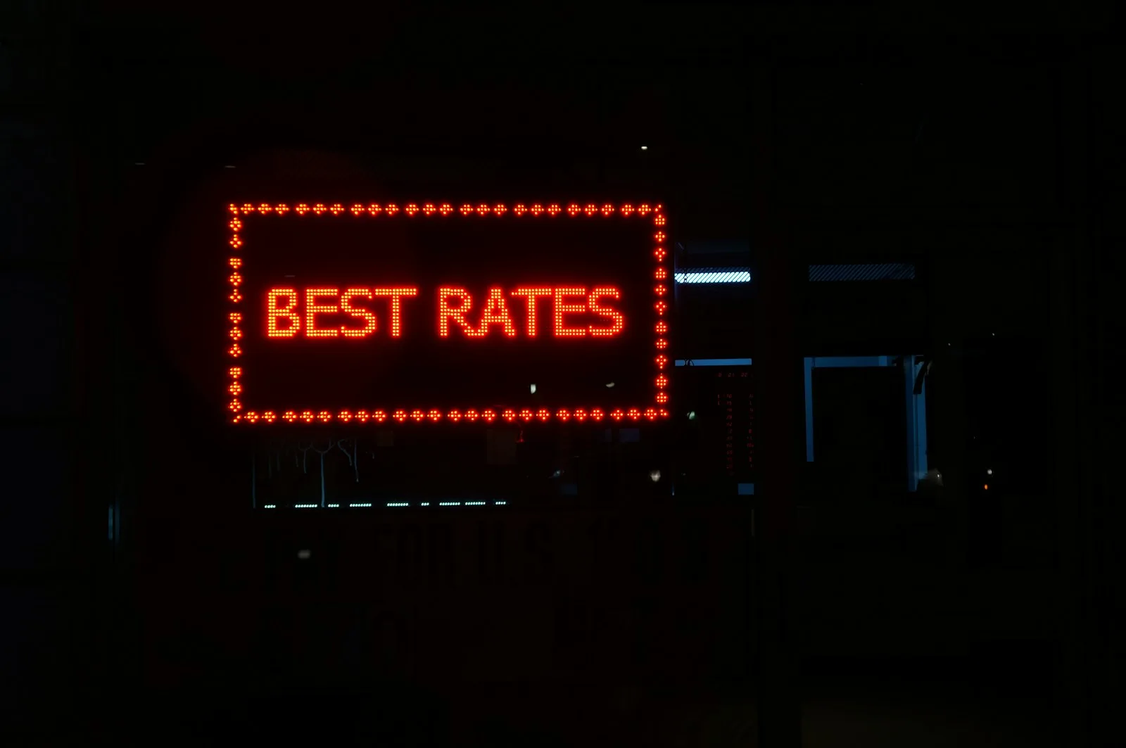 A glowing sign with the words “BEST RATES” written on top of it