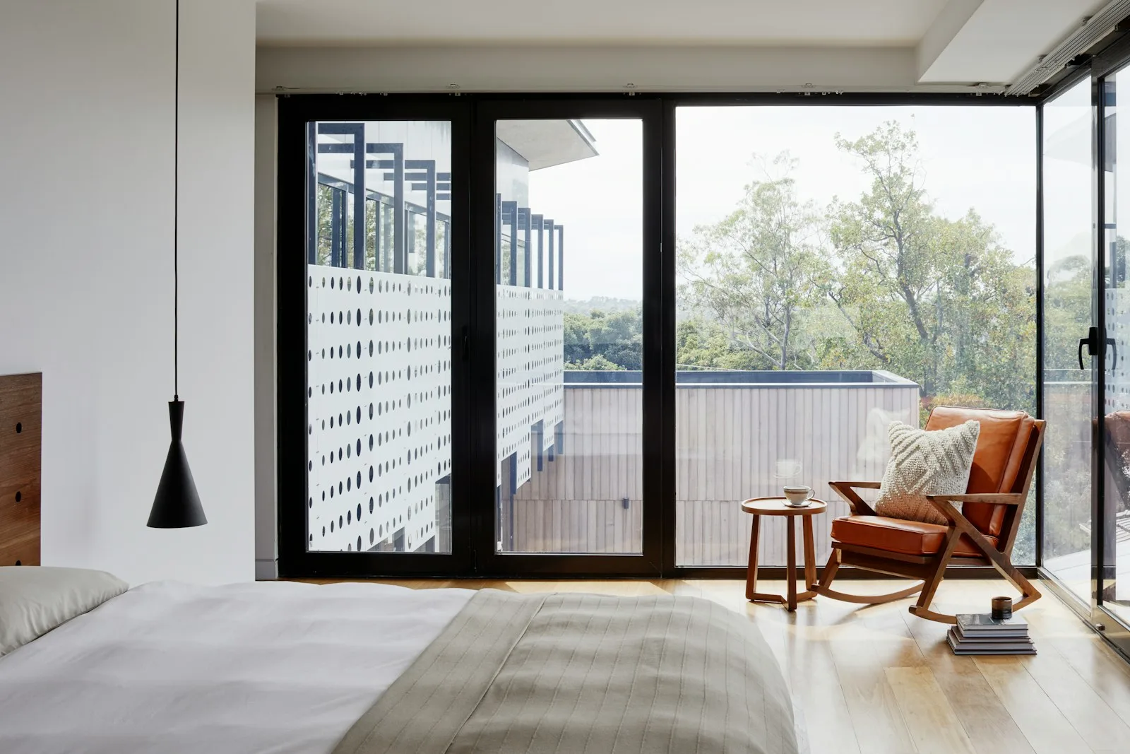 Image of a living room with a very big glass window and a chair