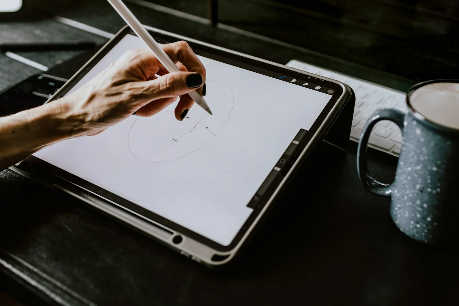 Image of someone drawing a digital cover on a touch screen device