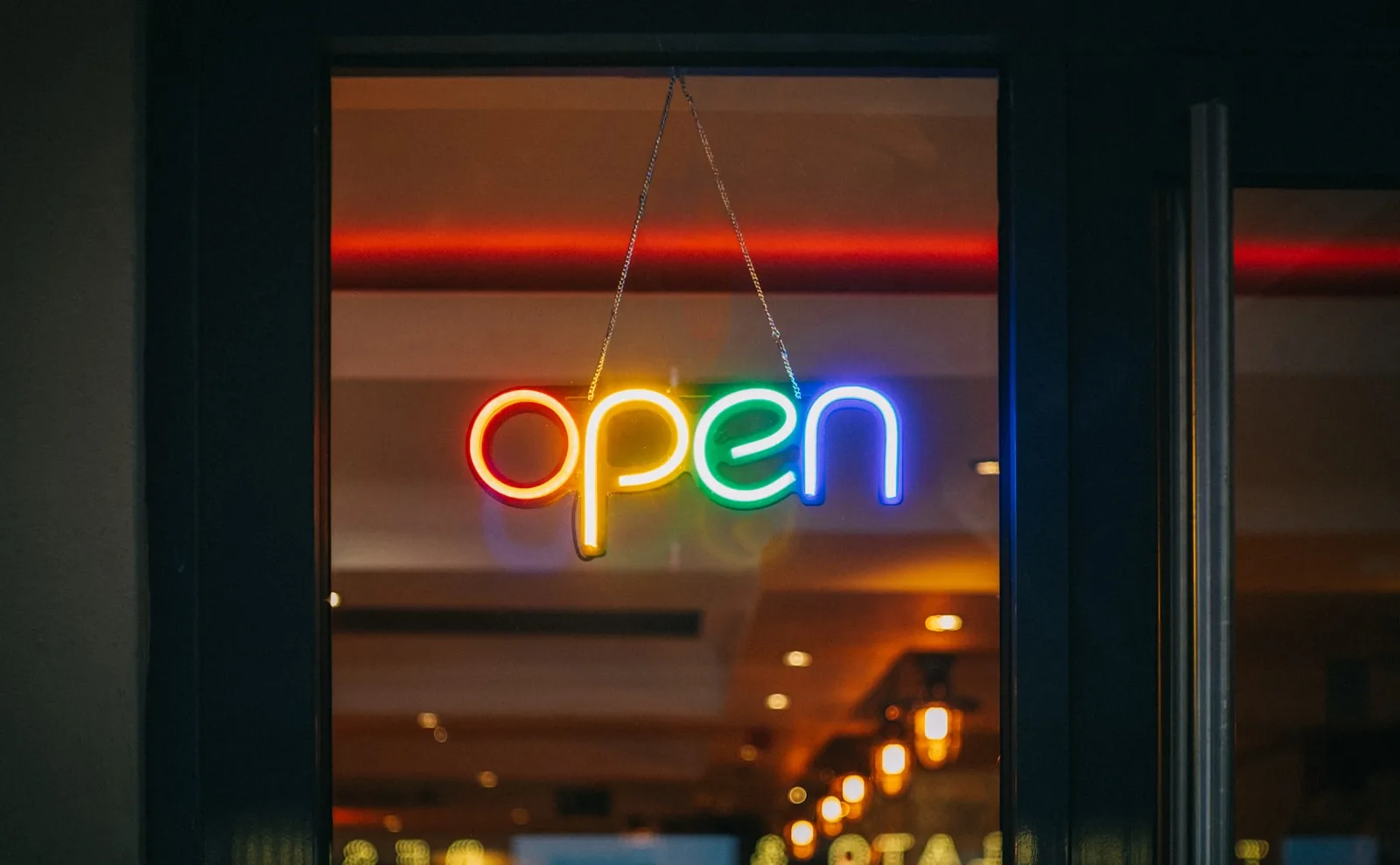 A glowing sign on the street mentioning the word “OPEN”