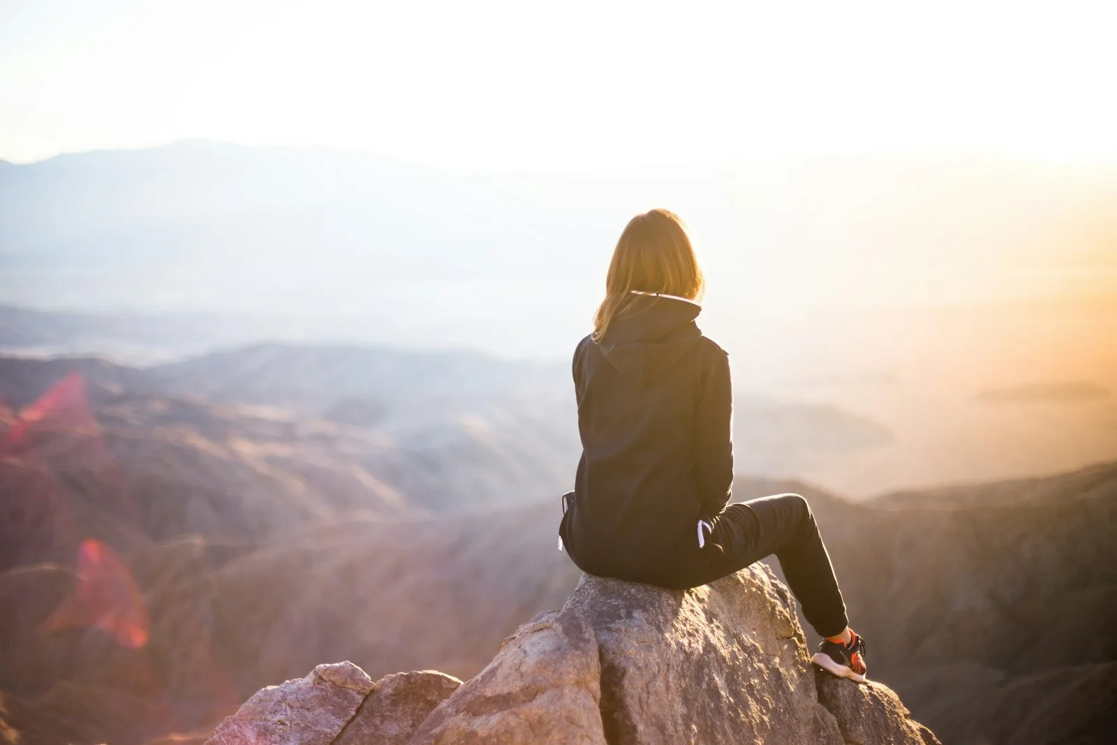 A person enjoying a setting sun over a mountain. An experience that doesn’t cost anything buy yet very satisfying.