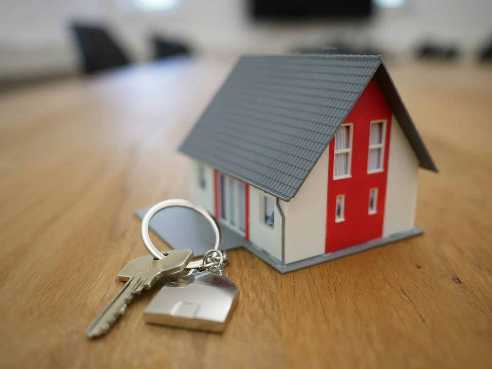 A model of a small house with a key in front of it
