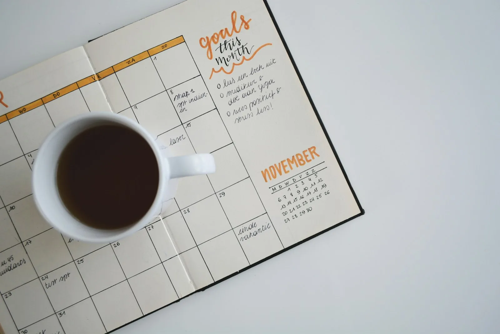 A person writing on a goal planner for the year. Much the same way we should have goals set for our finances in the long term as well.