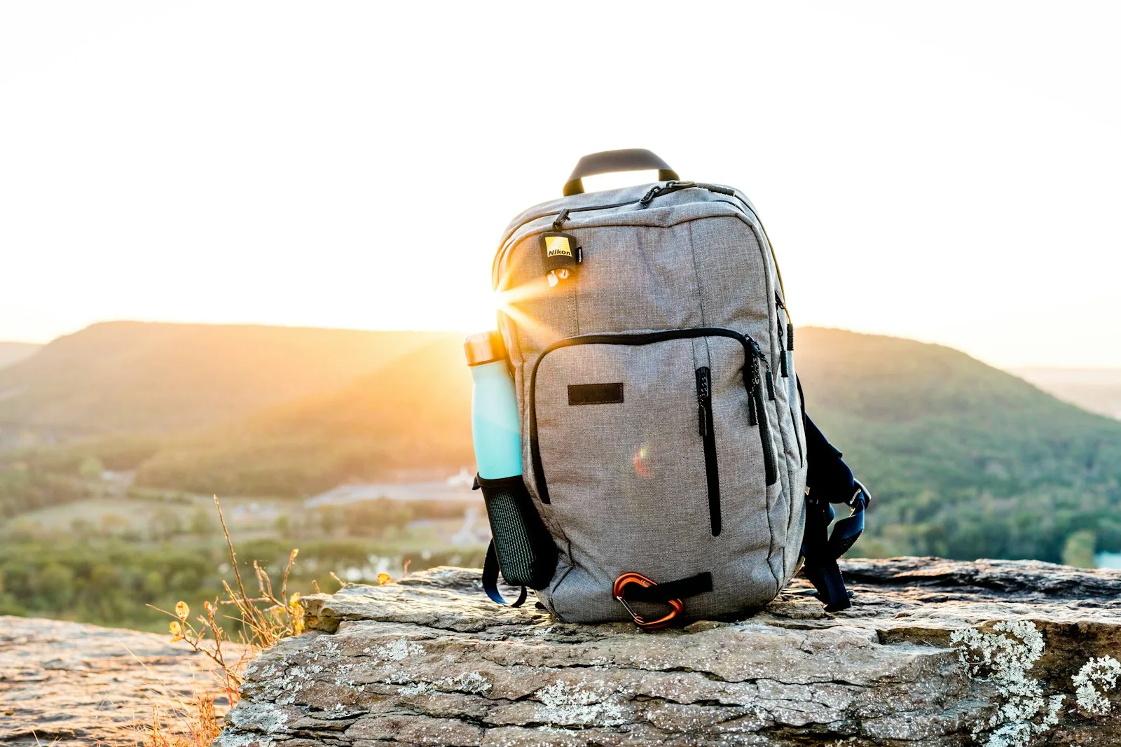 A person packing all essentials like water bottle and basic needs in a backpack while traveling in order to avoid unnecessary purchases